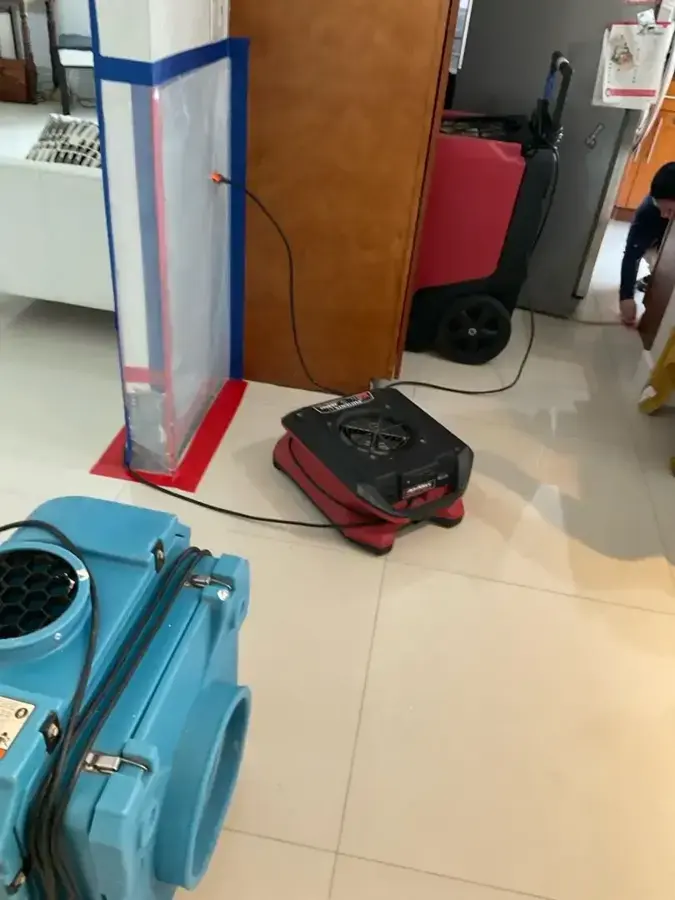 Air mover and dehumidifier drying a kitchen with a zippered containment door